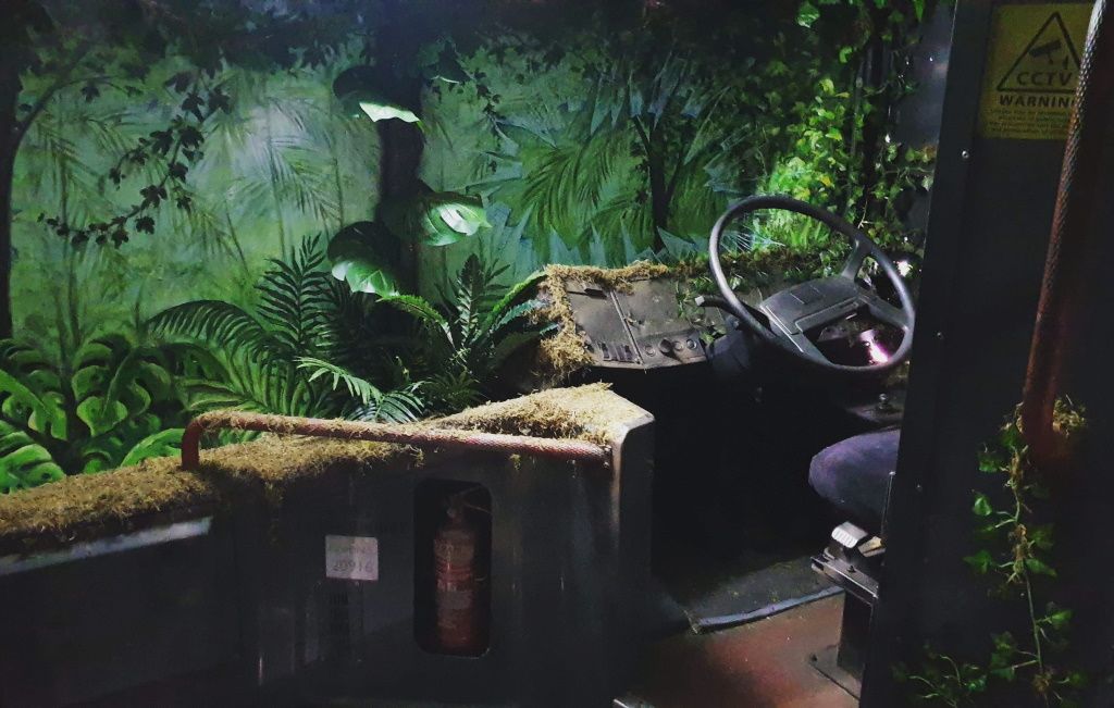 Inside Dino Deadlock: the cab of an overgrown research bus surrounded by jungle